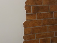 Immitation von einer verklinkerten Wand mit braunroten Klinkern.