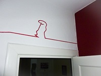 La LInea (Lui) läuft über einer Tür die Wand entlang, Linienfarbe rot